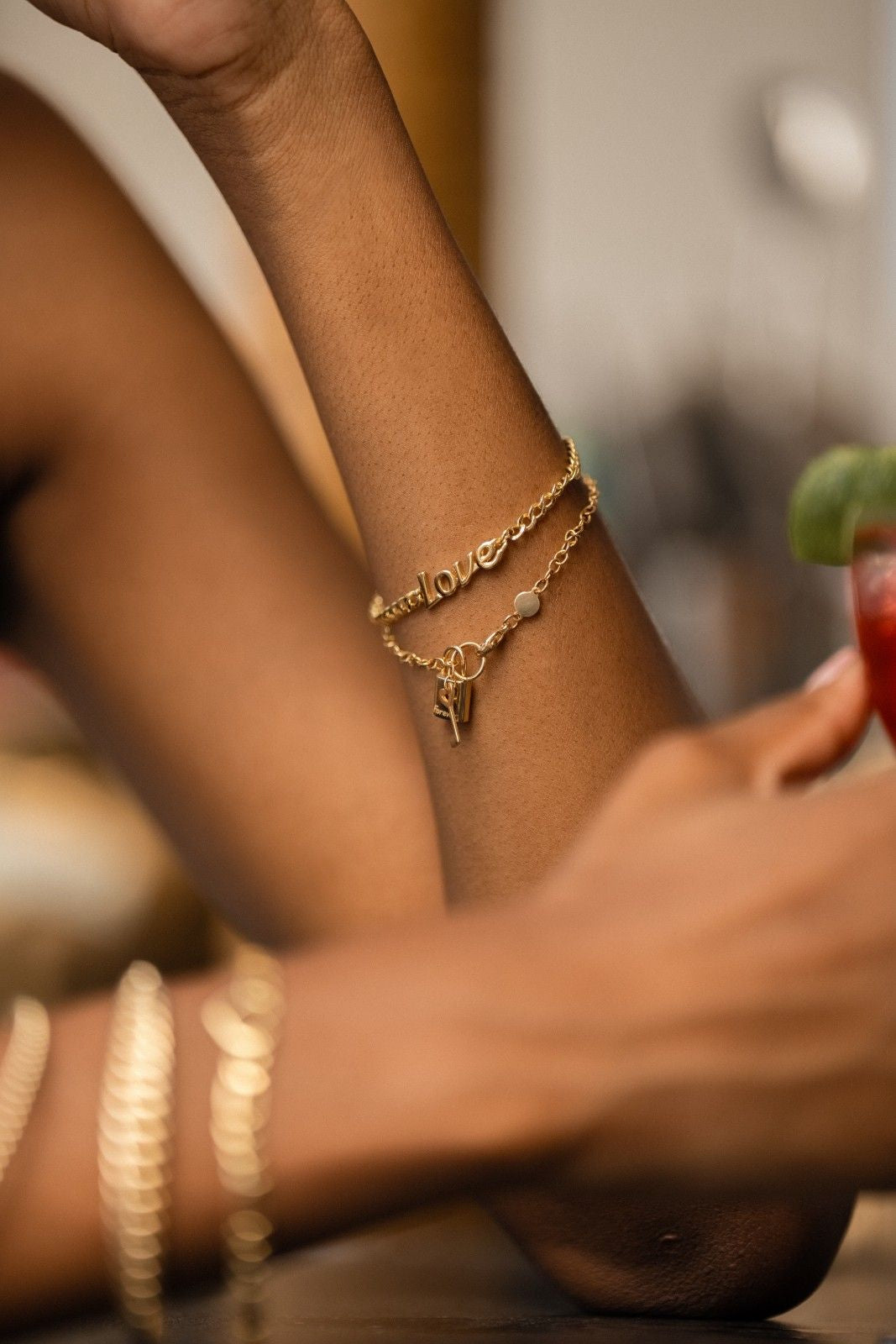14k gold chain bracelet featuring the word 'Love' in elegant script.