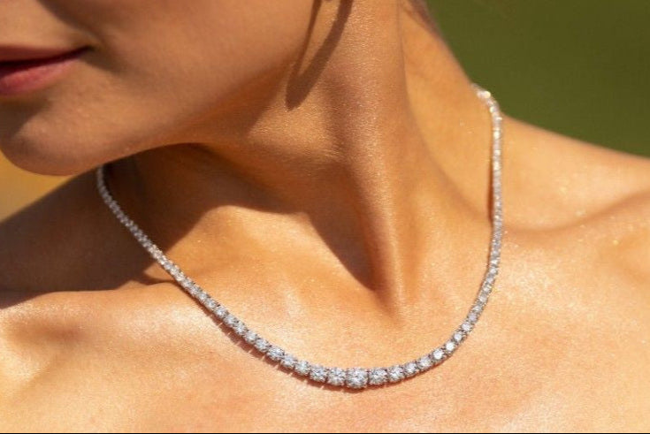 14k gold graduated diamond necklace with increasing diamond sizes toward the center, set in four-prong settings, symbolizing growth and transformation.